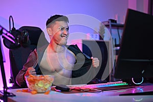 Aroused man watching pornographic sexual content on internet at night with pervert face expression. photo