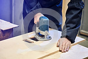 Ð¡arpenter working with milling machine. Joinery, woodworking and furniture making, professional carpenter cutting wood in