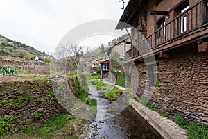 The Arrago river channel next to the typical houses built with slates quarried in the surrounding mountains