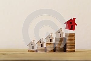 Arrange red outstanding small house or home on stacks of coins, Property investment real estate / Home loan / asset refinancing