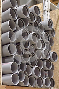 Arranged heap plastic pipes, grey shelf sold store