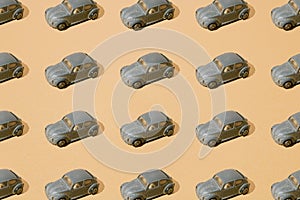 Arranged old small toy metal german car beetle. Peeled silver paint. yellow gold color background. Minimal pattern