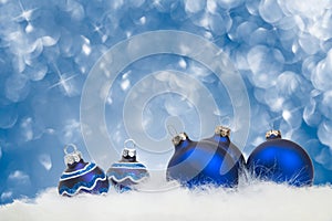 Arrangement of blue Christmas ornaments on blue background