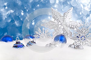 Arrangement of blue and silver Christmas ornaments on blue background