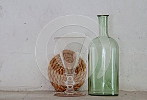 Arrangement with clear glass and old green bottle