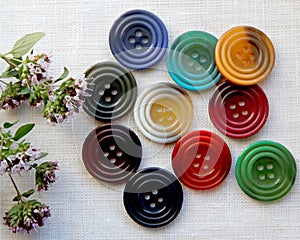 An arrangement of colorful buttons and pink flowers