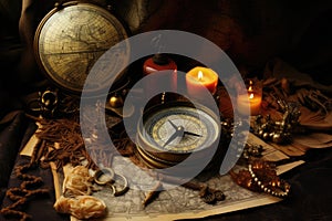 An arrangement of a compass, candles, and various objects on a table, Vintage still life featuring a compass, old map, and other