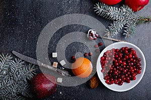 Arrangement, cranberries, a few twigs of fir-tree, orange and an apple. Top view.