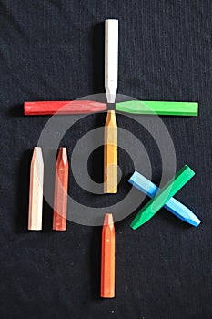 The arrangement of crayons forms a mathematical sign
