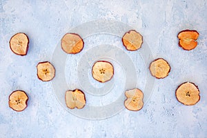 Arrangement of dried apple and dried orange slices on blue background