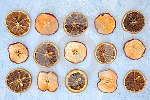 Arrangement of dried apple and orange slices on blue background