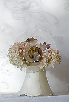 An arrangement of dry hydrangea flowers in textile vase