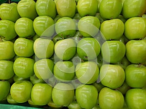 arrangement of fresh green apples on a market shelf