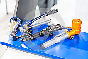 Arrangement of mechanical parts on a blue workbench, including a silver engine block and various metal components Organized in a