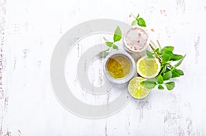 An arrangement of olive oil, himalayan salt, basil, lime and lemon