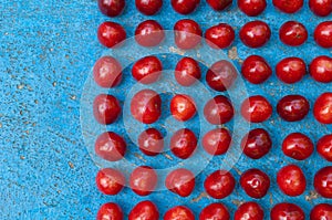 Arrangement of ripe cherries on blue textrured background
