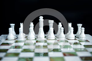Arrangement of white chess figures on marble green and white chess desk. Leadership in business is right start position. Chess