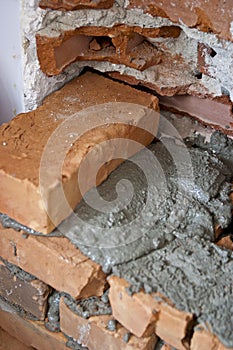 Arranging red bricks in to a demolished wall