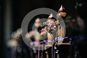 Array of miniature floral vases is arranged in a decorative fashion at a religious setting