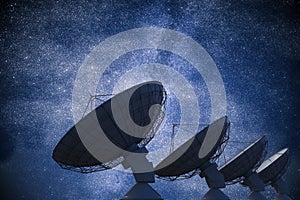 Array of satellite dishes or radio antennas against night sky. Space observatory. 3D rendered illustration