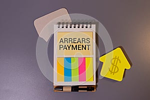 ARREARS PAYMENT - words on wooden blocks with a calculator in the background. Business concept.