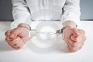 Arrested man handcuffed hands at the back isolated on gray background