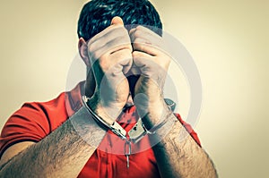 Arrested man in handcuffs hidden his face - retro style