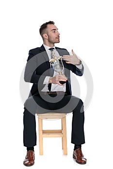 Arrogant businessman holding trophy and presenting himself