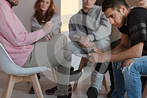 Arrogant teenager sitting at a meeting of support group while hi