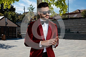 Arrogant young elegant man wearing red velvet tuxedo