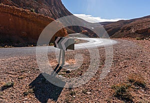 Arrow direction sign at Picturesque Serpentine mountain road in Gorges Dades in high Atlas, Morocco