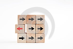 Arrow head icons on wooden blocks with one wooden block pointing to opposite direction. Change in business direction, unique,