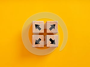 Arrow icons on wooden cubes moving to opposite directions photo