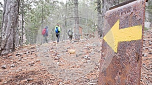 The arrow indicates the direction of the hiking trail and the direction of travel. Drawn on a metal suppo