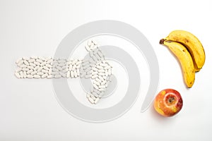 Arrow with pills pointing a fruit against supplements, concept of healthy nutrition