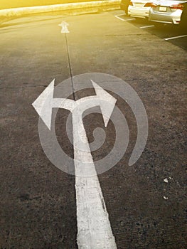Arrow pointing left and right on ground in a car park