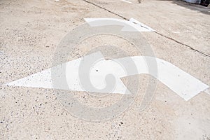 Arrow sign of turn, Old white painting on dirty concrete background