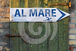 Arrow sign with the words To the Sea in italian language