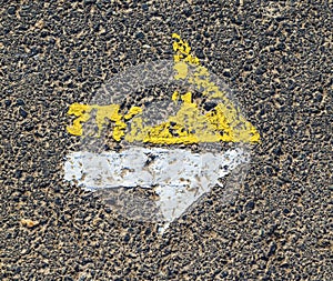 Arrow in yellow and white on a paveway for orientation