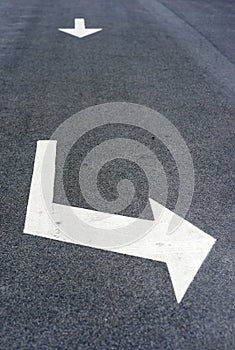 Arrows with direction signs on a asphalted street - image
