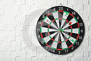 Arrows hitting dart board on white textured wall.  for text