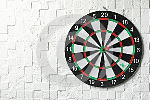 Arrows hitting dart board on white textured wall.  for text