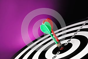 Arrows hitting target on dart board against purple background