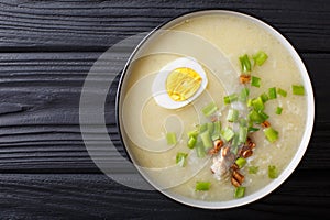 Arroz Caldo soup with rice, chicken and egg close-up. horizontal