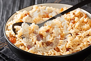 Arroz con coco is a flavorful Colombian side dish consisting of rice, coconut, sugar, salt, and raisins close-up in a bowl. photo