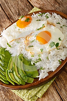 Arroz con huevo or rice with fried egg is the ultimate Latin lazy lunch close up in the plate. Vertical photo