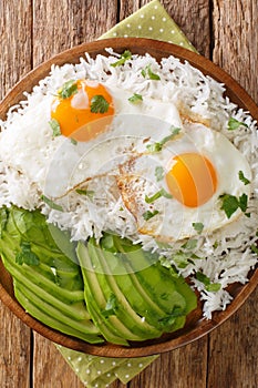 Arroz con huevo or rice with fried egg is the ultimate Latin lazy lunch close up in the plate. Vertical top view photo