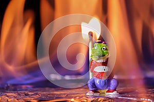 Arsonist on fire. A crocodile toy stands with a match in a fiery flame. Fire and fire concept