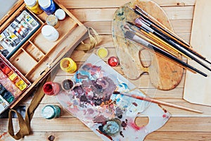 Art brush and colored inks in cans on a dark background.