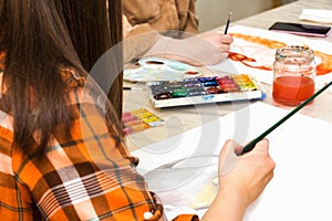 Art class in school, artist student paints in studio. Painting in classroom. Female hand with paintbrush